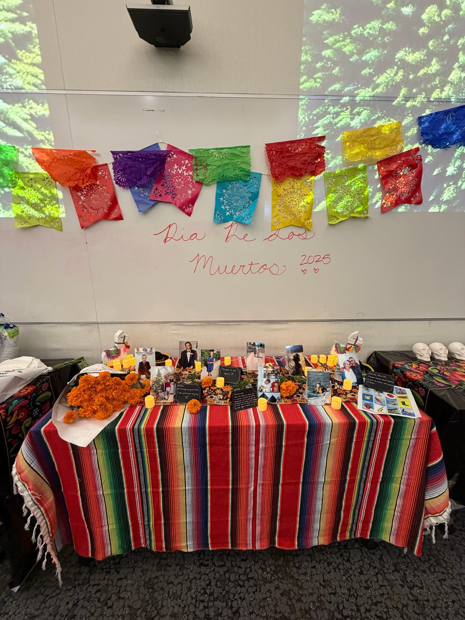 A Día de los Muertos altar decorated with papel picado, marigolds, and candles.