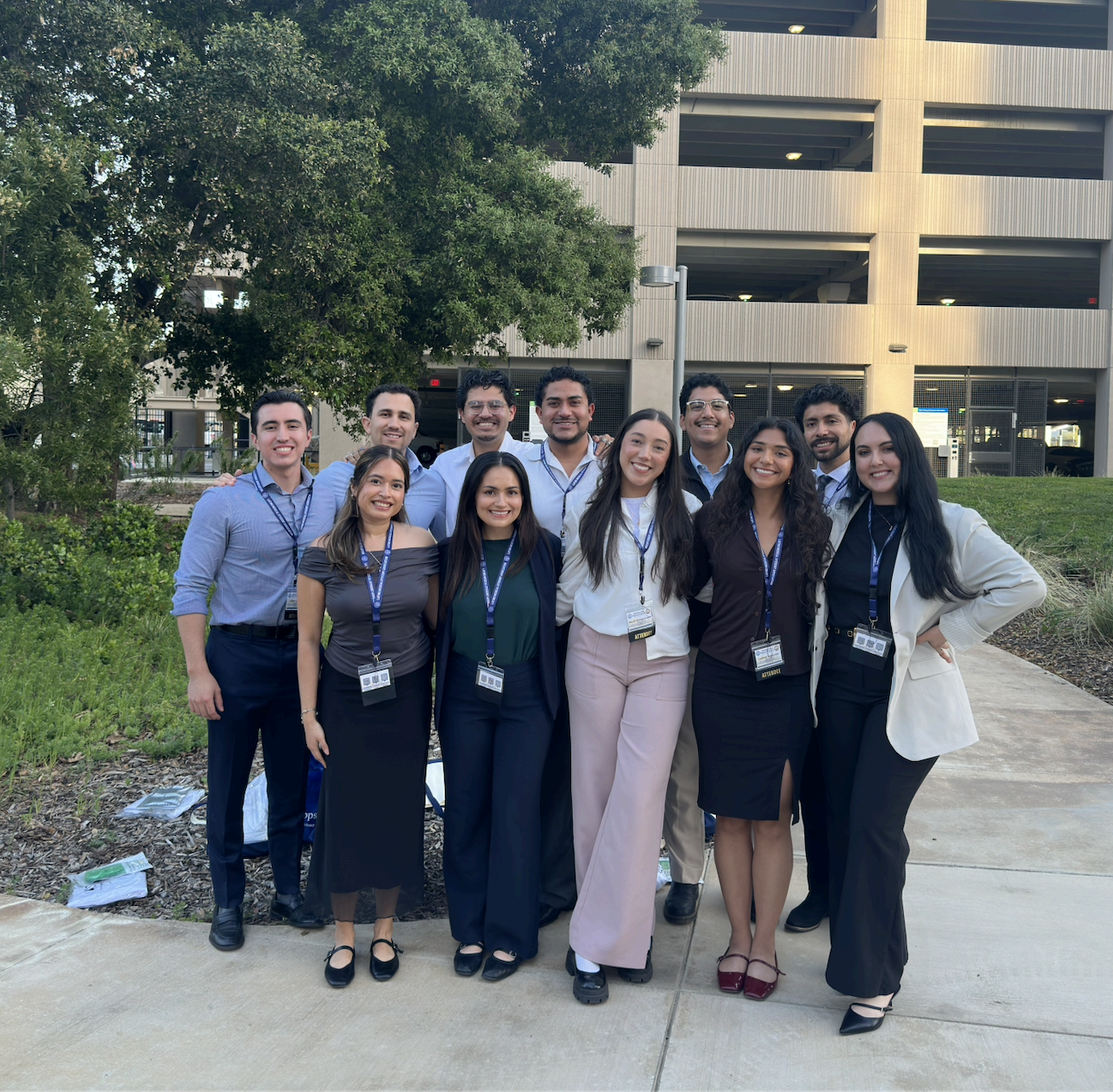A group of LMSA at UCSF students posing together outdoors in front of a parking structure.